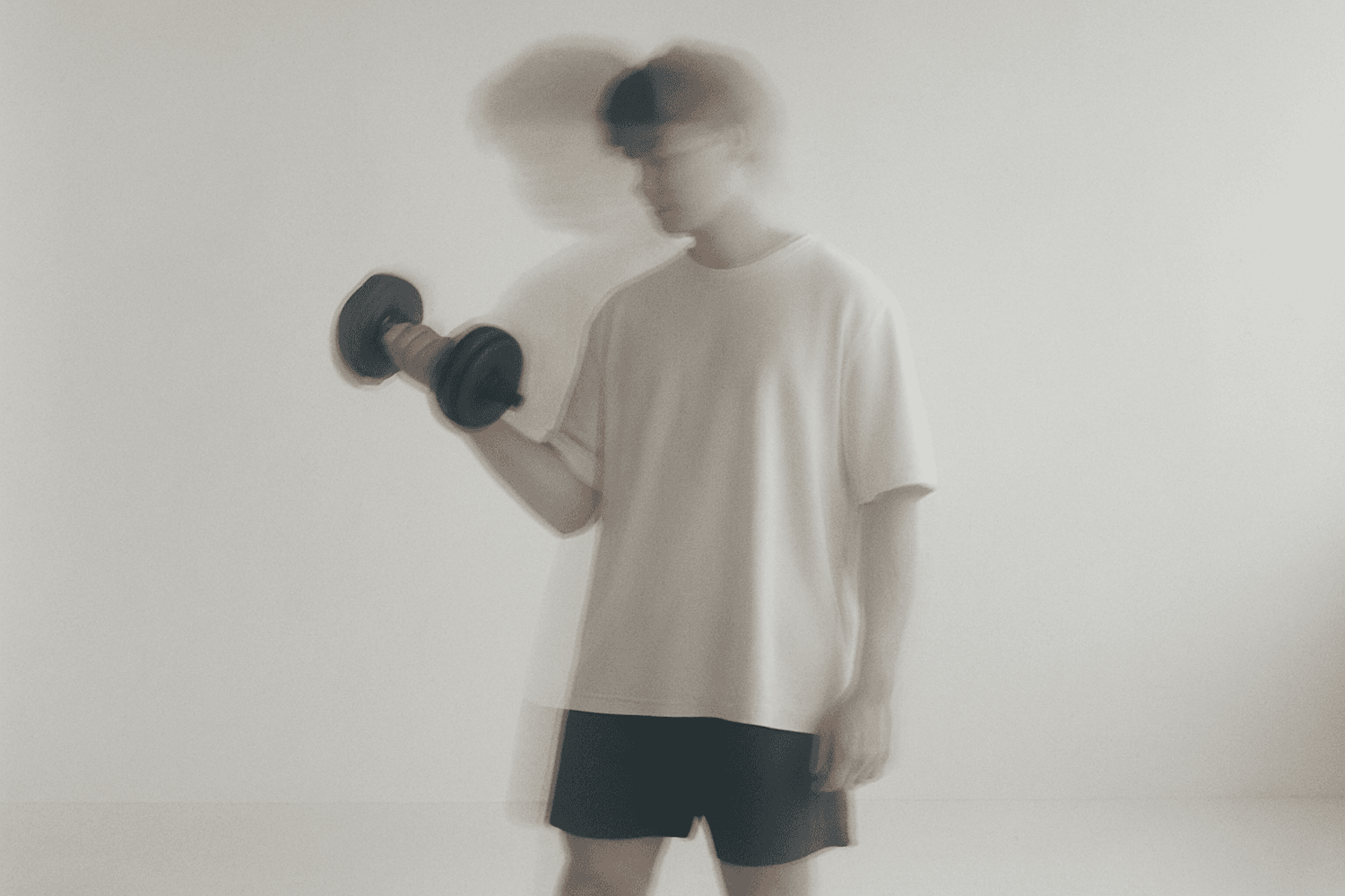 Motion-blurred dumbbell press mid-repetition